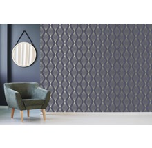 Scène avec un mur avec du papier peint géométrique, un miroir rond et un fauteuil.