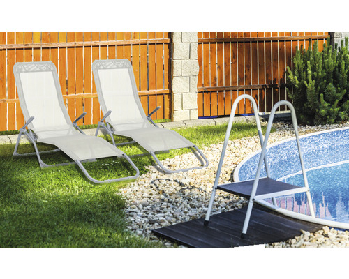 Szene mit zwei Gartenliegen und einer Poolleiter im Garten
