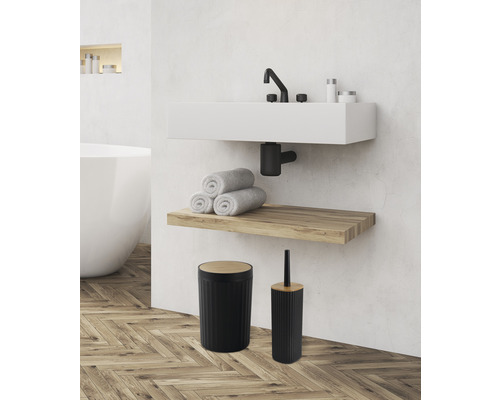 Salle de bain avec lavabo, serviettes, étagère en bois, poubelle et brosse de toilette