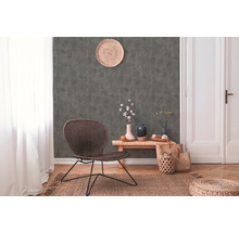 Salon avec chaise en rotin, mur décoratif et plancher en bois