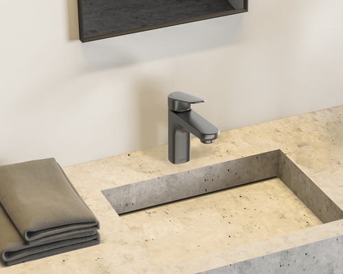 Waschtischarmatur auf Betonwaschbecken mit Handtüchern