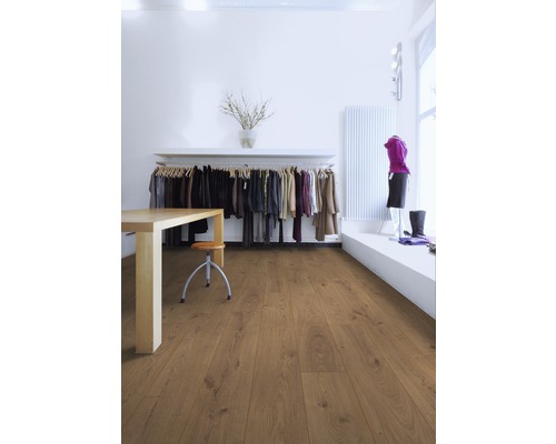Pièce lumineuse avec sol stratifié, table, chaise et portant à vêtements