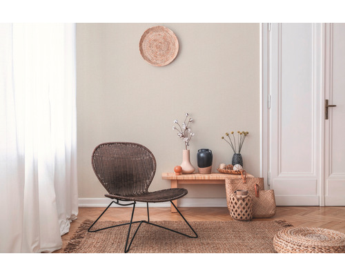 Wohnzimmer mit Korbsessel, Holzbeistelltisch, Dekoration und Teppich