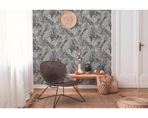 Pièce avec papier peint jungle gris, meubles en rotin et parquet pour une ambiance naturelle