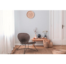 Wohnzimmer mit Rattansessel, Holzbeistelltisch und Dekoration