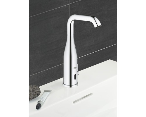 Berührungslose Armatur auf einem Waschbecken mit Bimsstein und Creme Tube, im Badezimmer.