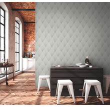 Salon avec papier peint à motifs, parquet et table à manger avec chaises.