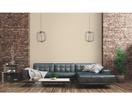 Wohnzimmer mit Sofa, Tisch und Dekoration vor einer Backsteinwand