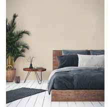 Schlafzimmer mit Holzbett, Beistelltisch, Zimmerpflanze und Teppich auf Holzboden