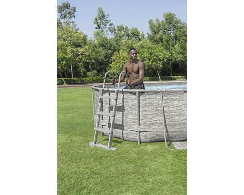 Aufbaubecken mit Leiter und darin stehender Person im Garten