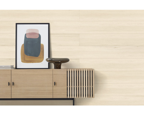 Scène de salon avec plancher en bois clair, buffet, décorations et une image encadrée.