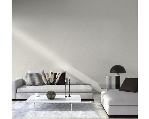 Salon avec canapé, table et décoration devant un mur clair