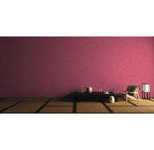 Asiatisch eingerichteter Raum mit Tatamiboden, dunklem Tisch, Teegeschirr, Sessel und Lampe vor einer Wand