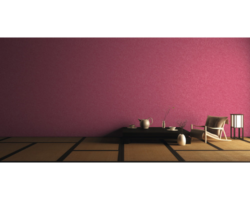 Asiatisch eingerichteter Raum mit Tatamiboden, dunklem Tisch, Teegeschirr, Sessel und Lampe vor einer Wand