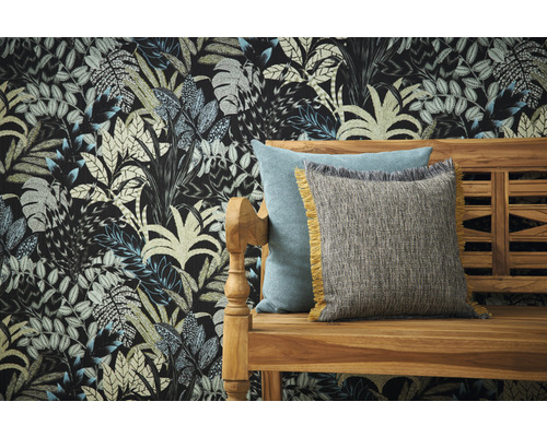 Coussins décoratifs sur un banc en bois devant un mur avec du papier peint à motifs de feuilles.