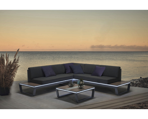 Gartensitzgruppe mit Ecksofa, Couchtisch und Kissen vor einem See