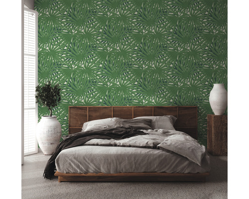 Chambre à coucher avec papier peint à feuilles vertes, lit et décoration