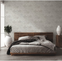Chambre avec papier peint à motifs, lit et plante d''intérieur