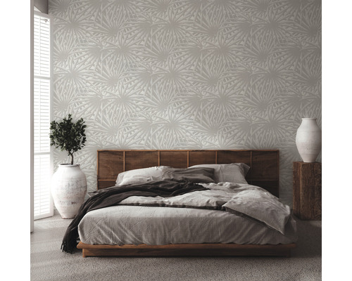 Schlafzimmer mit gemusterter Tapete, Bett und Zimmerpflanze