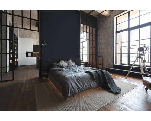 Schlafzimmer im Loft-Stil mit Bett, Fenstern und Küchenbereich
