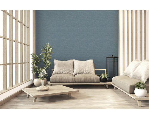 Salon lumineux avec meubles en bois, plantes et fond texturé