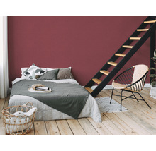 Chambre avec lit, échelle, chaise et mur rouge