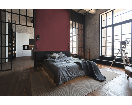 Chambre lumineuse de style loft avec lit, tapis, fenêtres et coin cuisine
