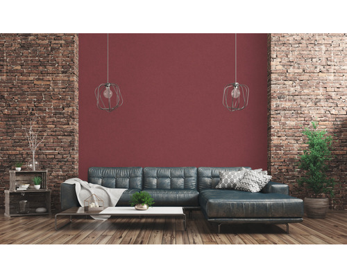 Salon avec canapé en cuir, table basse, décoration et mur en briques