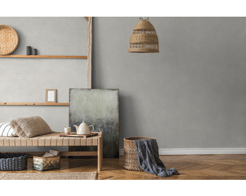 Helles Zimmer mit Rattanlampe, Wandregal und grauer Tapete