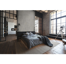 Schlafzimmer im Loft-Stil mit Bett, Teppich und großen Fenstern