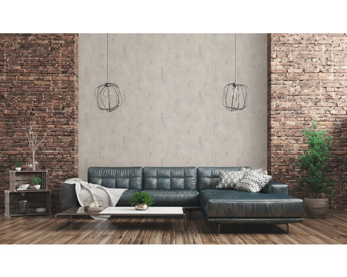 Salon avec canapé en cuir, table basse, étagères et éléments décoratifs devant un mur en briques