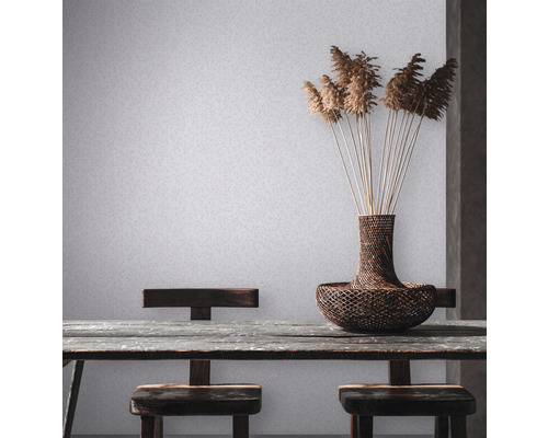 Scène avec table, chaises, vase et décoration devant un papier peint mural clair.