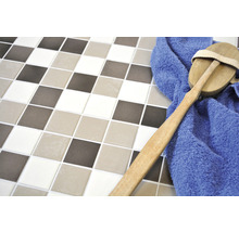 Carreaux carrés de différentes couleurs avec une brosse et une serviette bleue