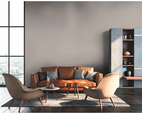 Wohnzimmer mit Ledersofa, Sesseln, Couchtischen und Regalen