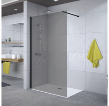 Paroi de douche à l'italienne en verre teinté avec barre de fixation noire et système de douche dans une salle de bain moderne.