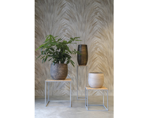 Scène décorative avec une plante d''intérieur, un grand pot de fleurs et un petit pot de fleurs sur des tabourets devant un mur à motifs