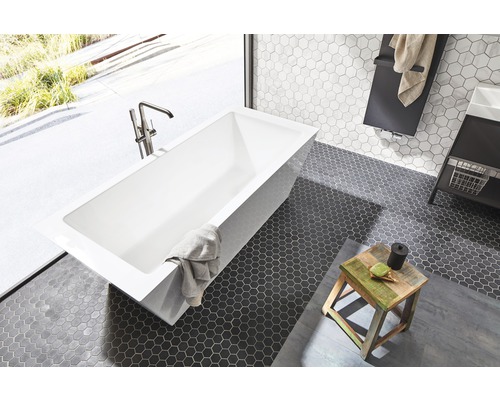 Salle de bains avec baignoire rectangulaire, robinetterie et carrelage hexagonal au sol.