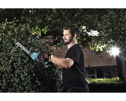 Homme coupant une haie avec un taille-haie sans fil