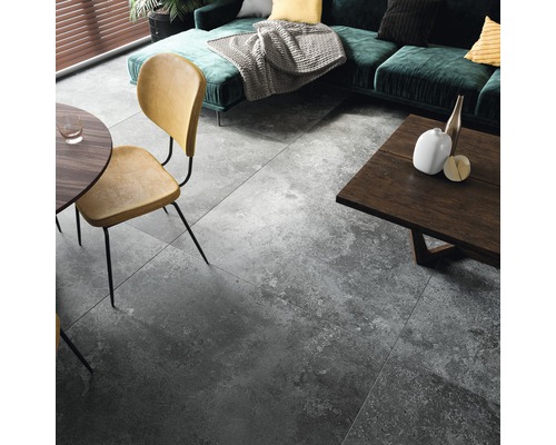 Wohnzimmer mit grauen Bodenfliesen, Sofa, Tisch und Stühlen