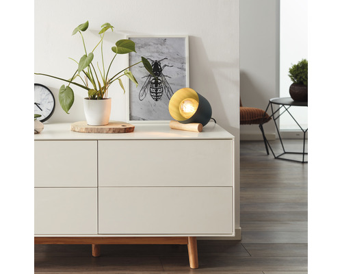 Dekorative Tischleuchte auf einem Sideboard in einem hellen Raum.