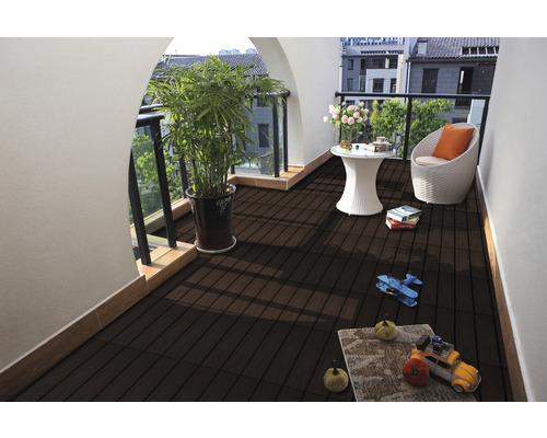 Balcon avec lames de terrasse en bois foncé, plante, table et chaise