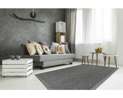 Salon moderne avec canapé gris, tapis et coussins décoratifs