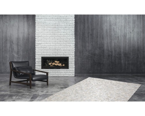 Wohnzimmer mit Sessel, Teppich und Kamin.