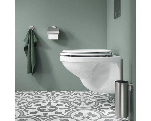 Modernes Badezimmer mit wandhängendem WC, Handtuch, Toilettenpapierhalter und Toilettenbürste