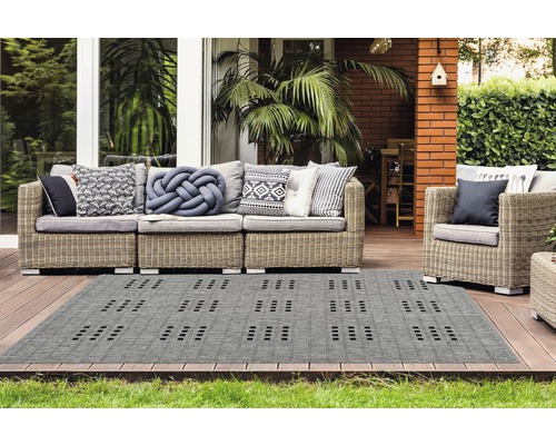 Tapis d''extérieur gris avec motif géométrique sur une terrasse avec mobilier de jardin
