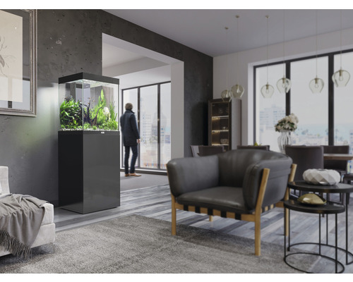 Salon avec aquarium sur meuble bas, fauteuil et table à manger.