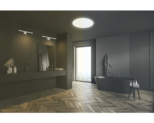 Modernes Badezimmer mit Badewanne, Waschtisch, Spiegel, Wandleuchten und Deckenleuchte