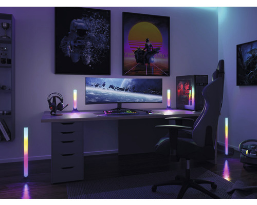 Gaming Zimmer mit Schreibtisch, Monitor, Computer, Gaming Stuhl und farbigen Lichtleisten.
