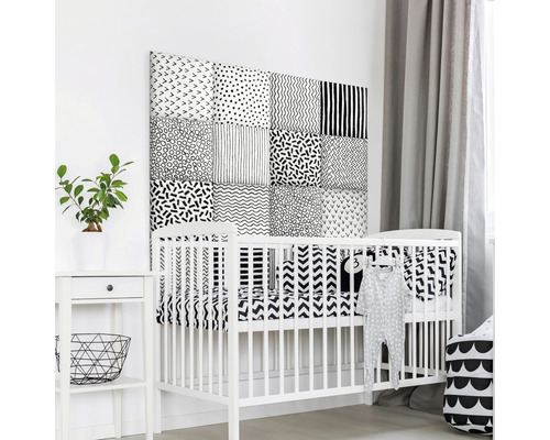 Chambre de bébé avec lit d''enfant blanc et panneaux muraux aux motifs variés.
