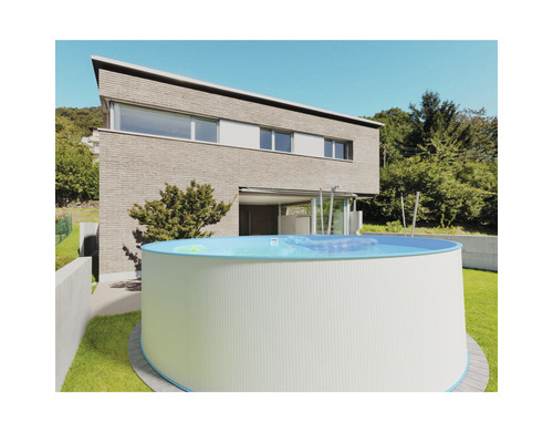 Piscine hors sol ronde en acier dans le jardin devant une maison moderne
